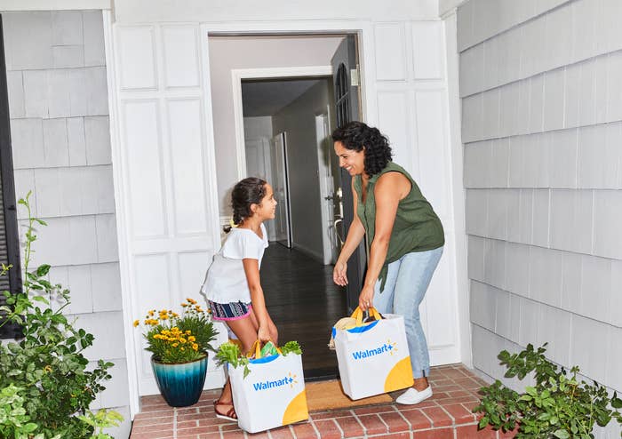 Mother and daughter carrying Walmart grocery bags