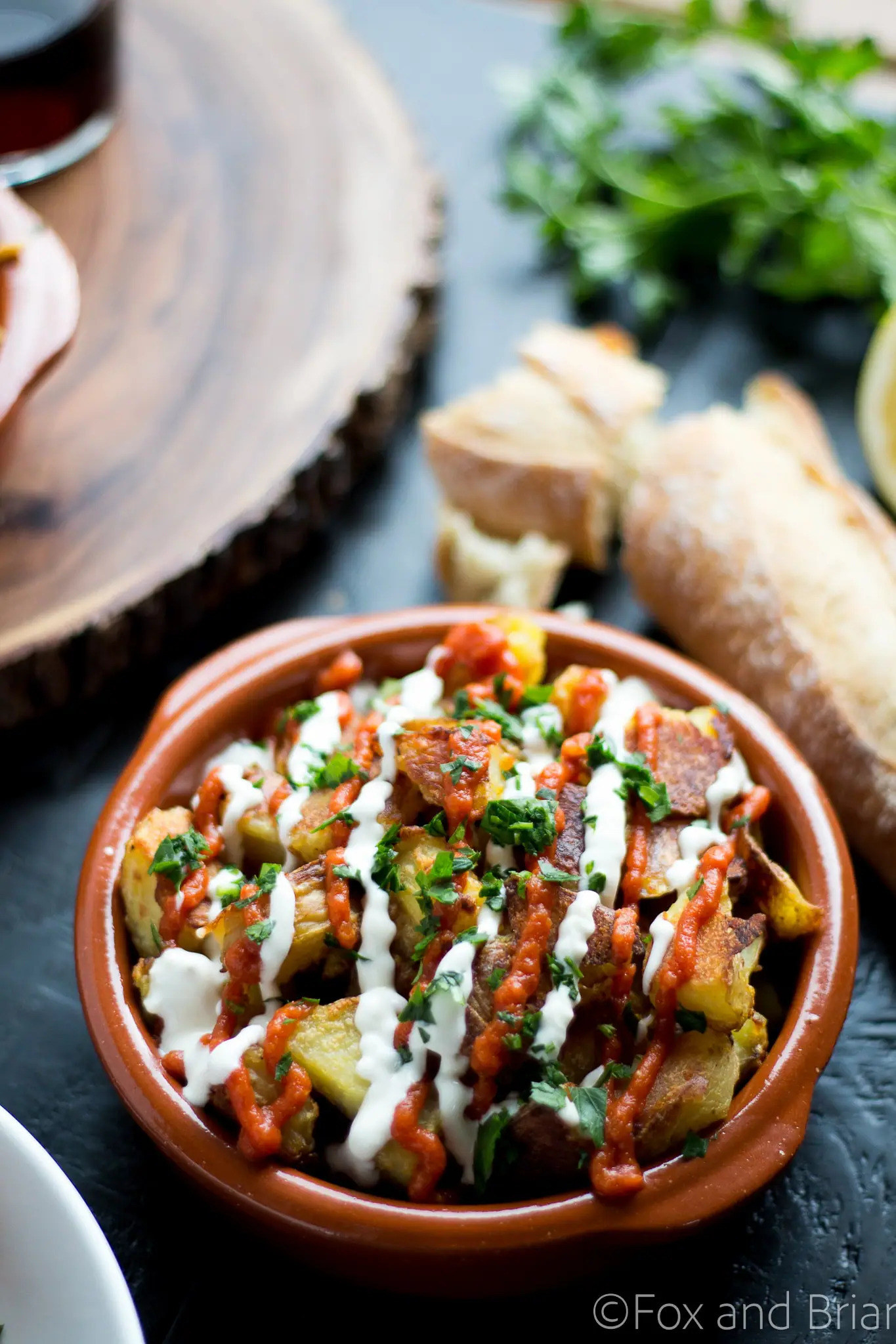 Patatas Bravas drizzled with sauce in a serving dish