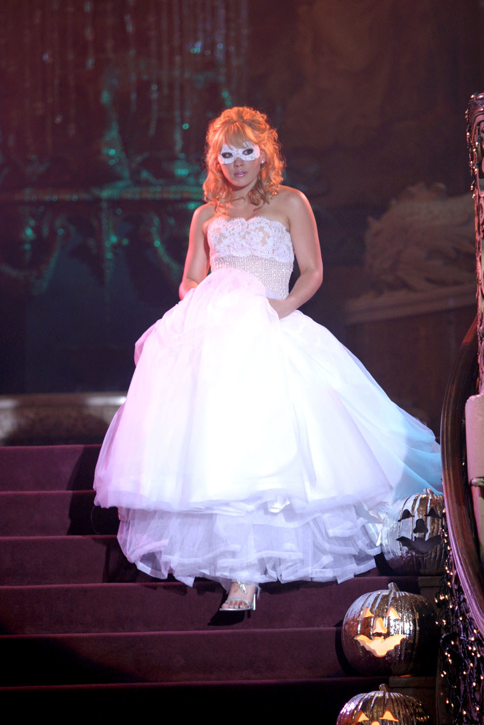 Andie enters the dance wearing a ballgown and a mask
