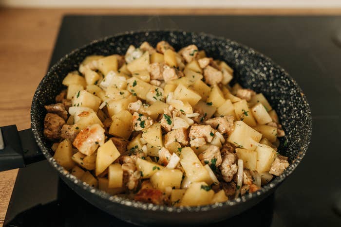 cubed potatoes in a skillet with various seasonings