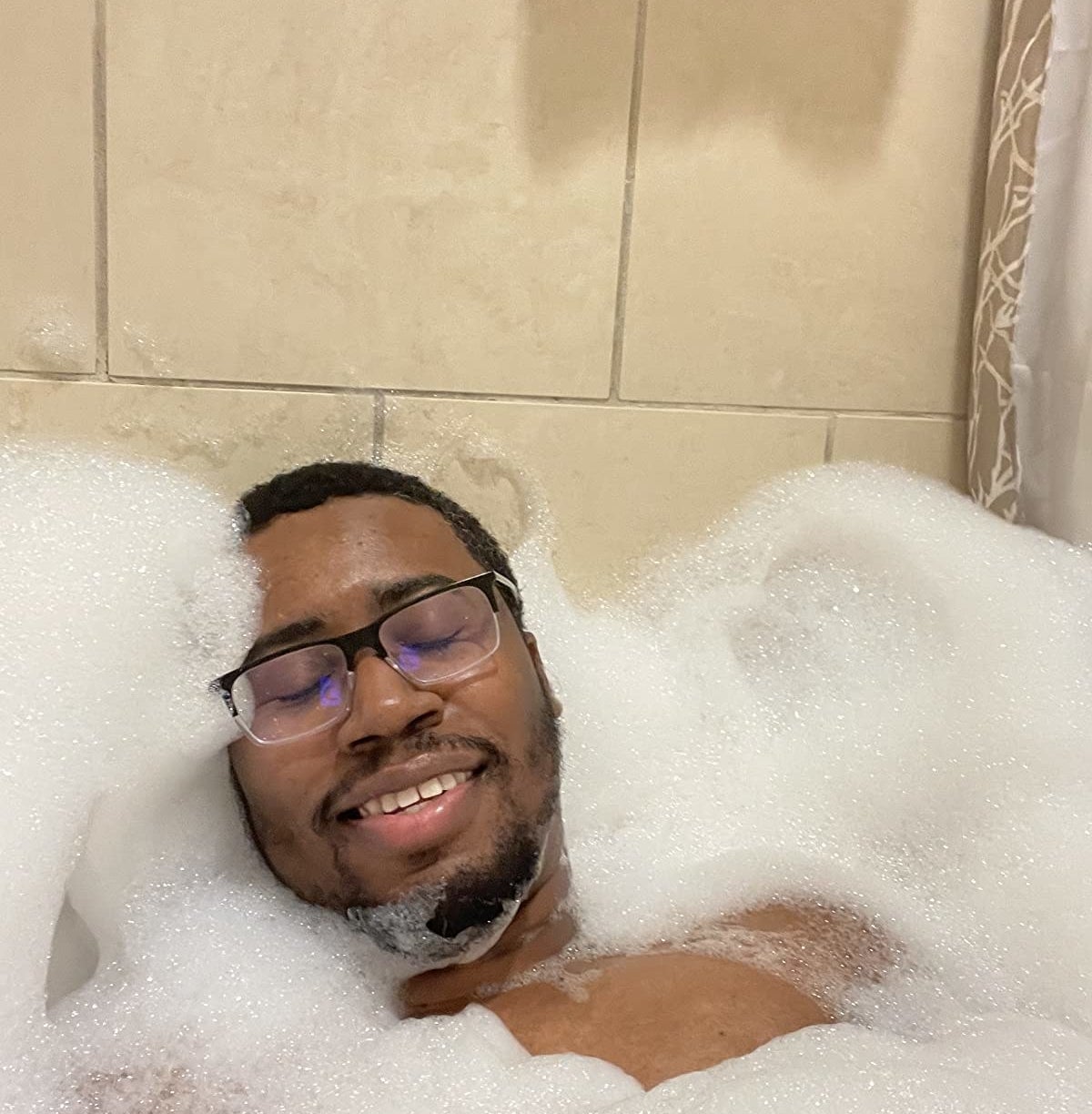 Reviewer enjoying a bubble-filled bathtub