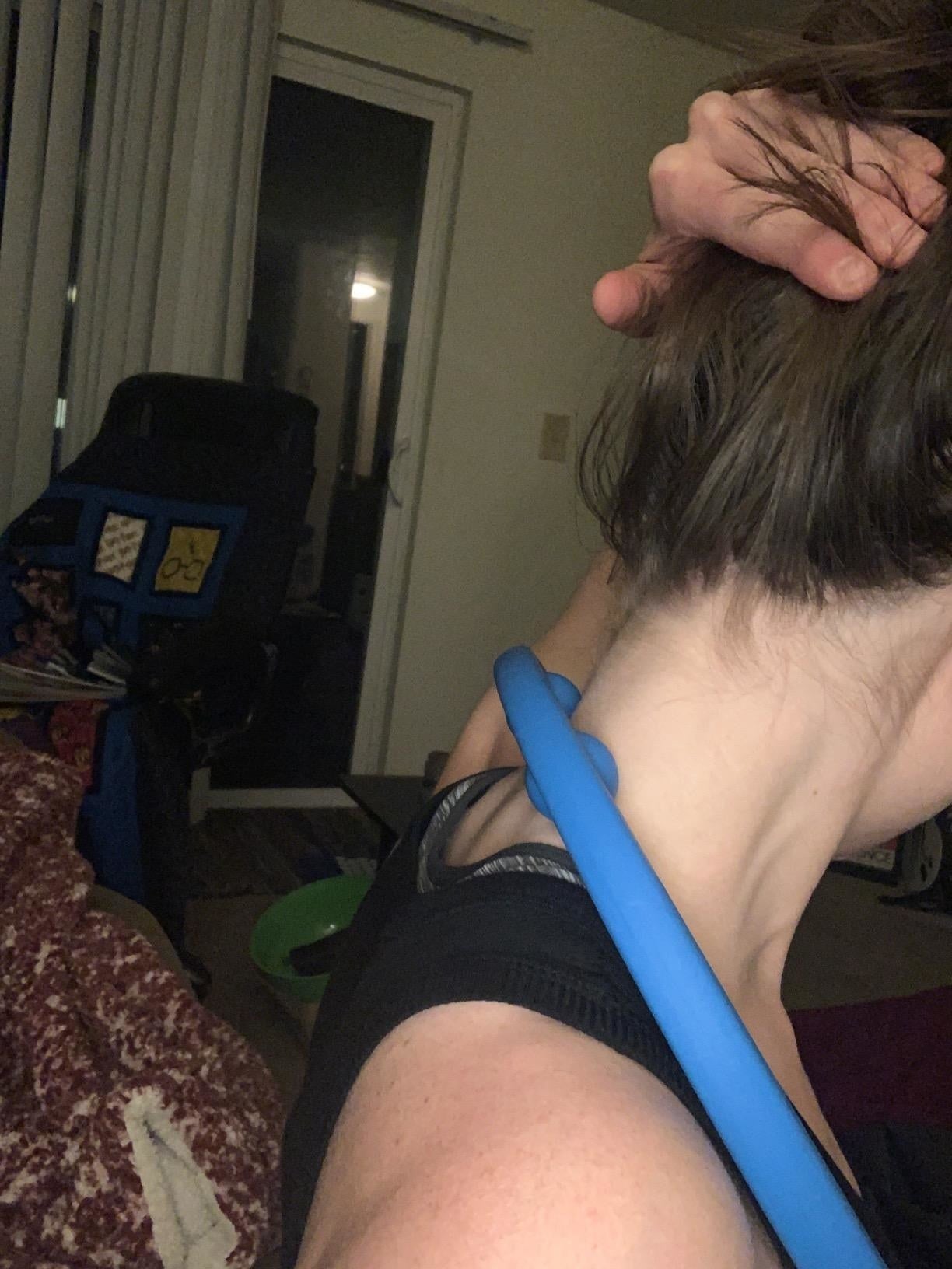 Reviewer utilizing the massager connected  their neck