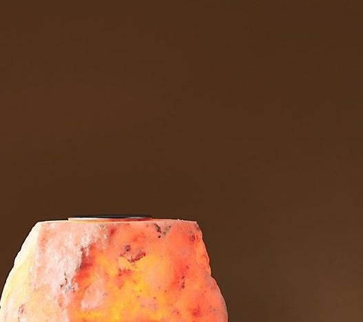 A Himalayan salt oil warmer turned on with glowing lights