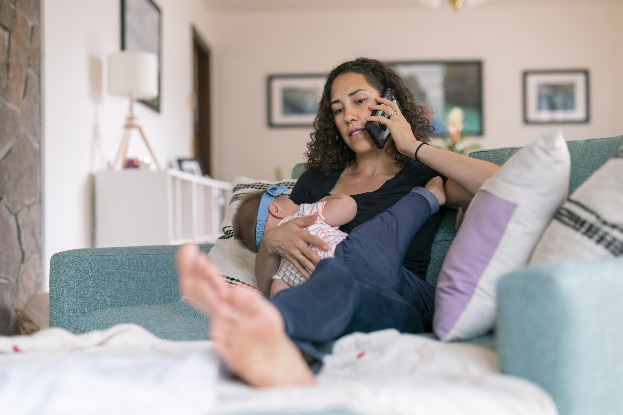 A woman on the phone while breastfeeding
