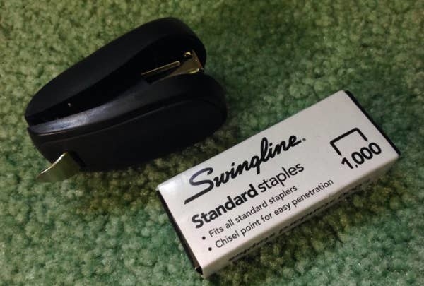 Reviewer&#x27;s mini stapler in black next to the pack of refill staples