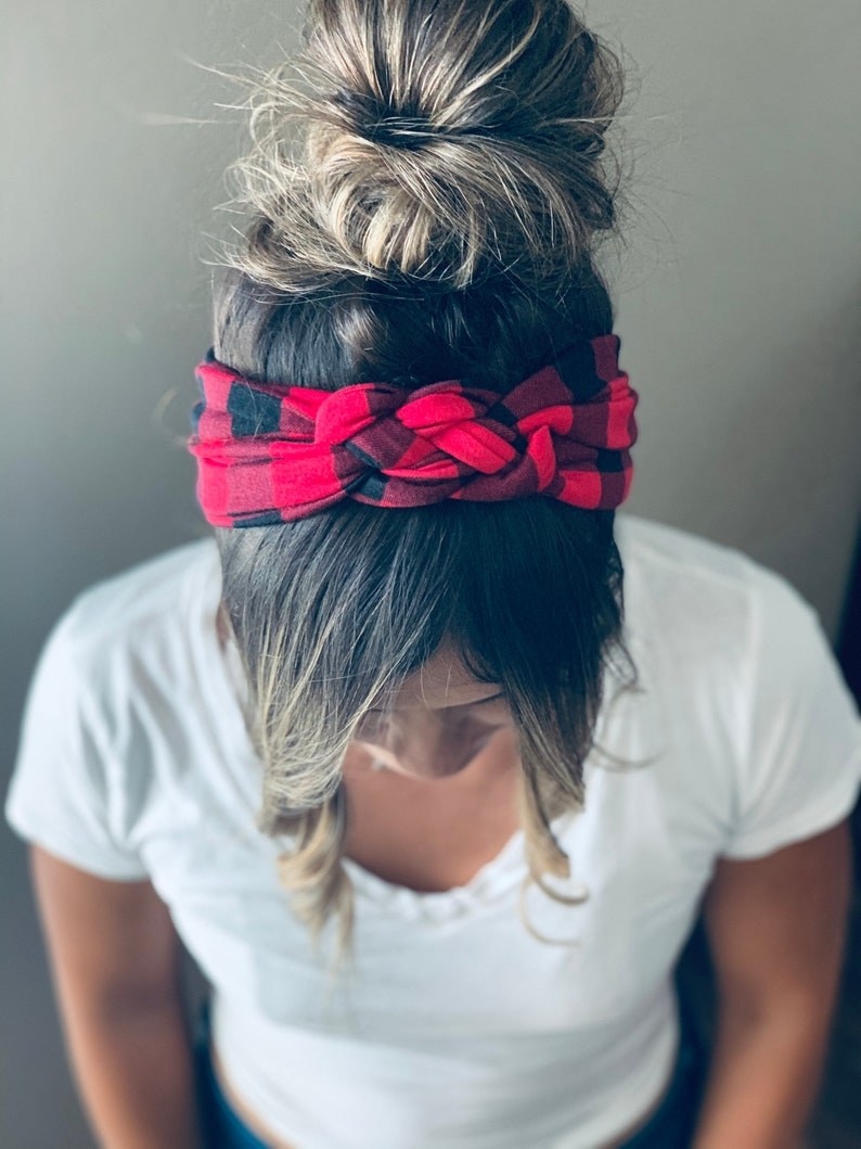 A woman wearing a black and red plaid headband.
