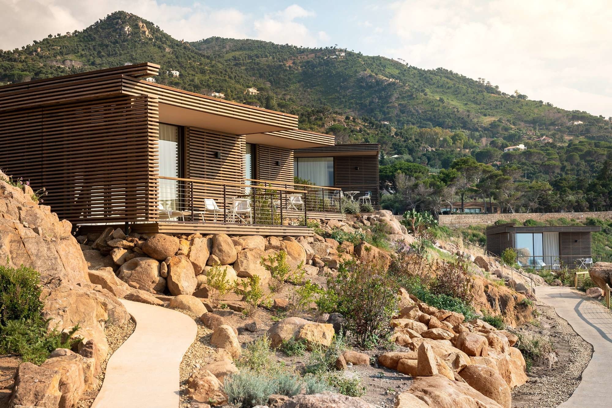 modern cliffside suites in Sicily&#x27;s countryside with mountains in the background