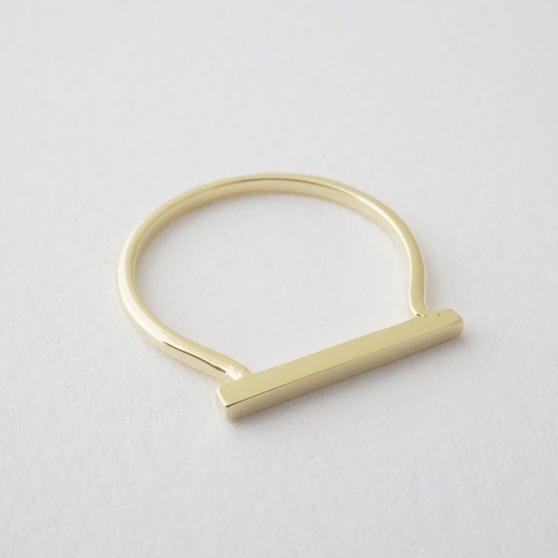 A golden ring with a long bar top.