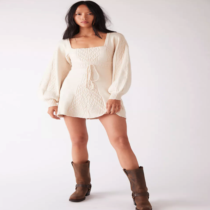 model wearing the long sleeve dress in cream with unique knit details on the bubble sleeves and throughout the dress.