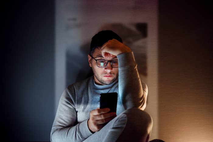 Person looking worried while reading something on their phone