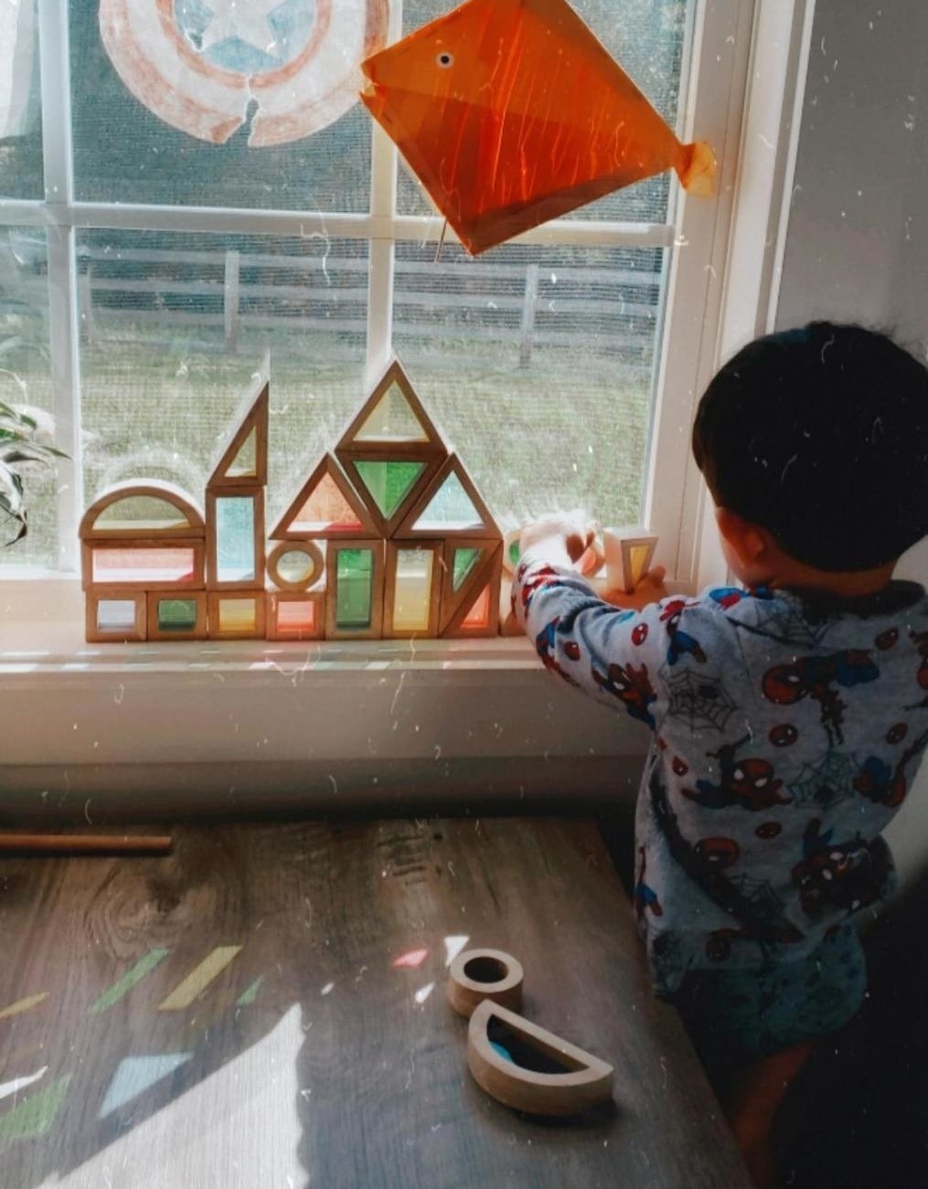 Reviewer&#x27;s photo of the blocks against a window as a child plays with them