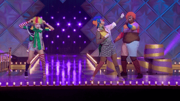 three queens dressed as clowns on stage.