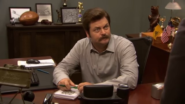 Ron at his desk talking to Leslie in &quot;Parks and Recreation&quot;