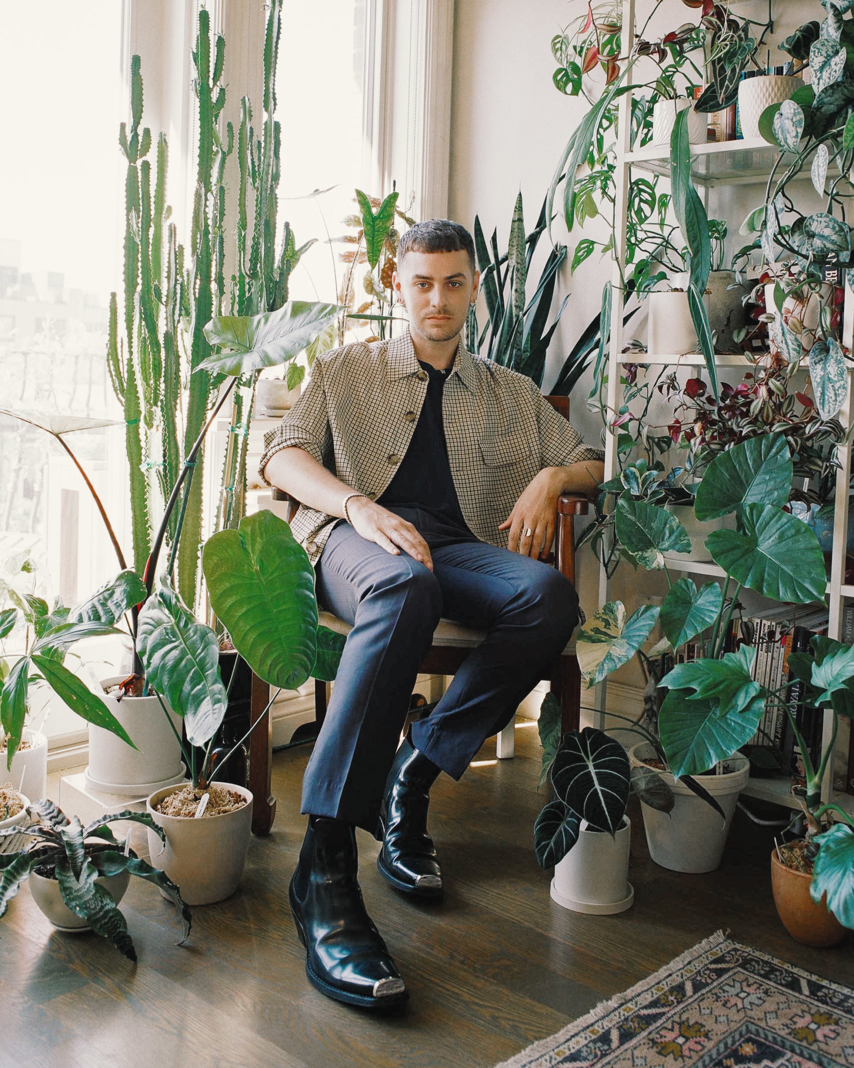 Eric White sits in a chair amid plants