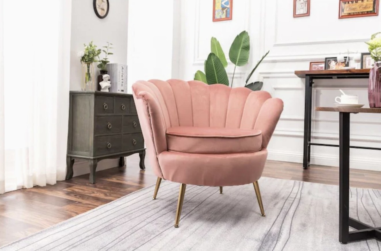Pink velvet accent chair resting on a carpet