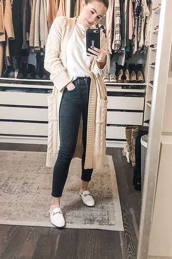 A reviewer wearing the loafer mules in white.