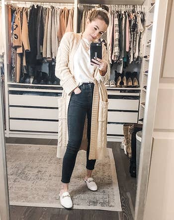 A reviewer wearing the loafer mules in white.