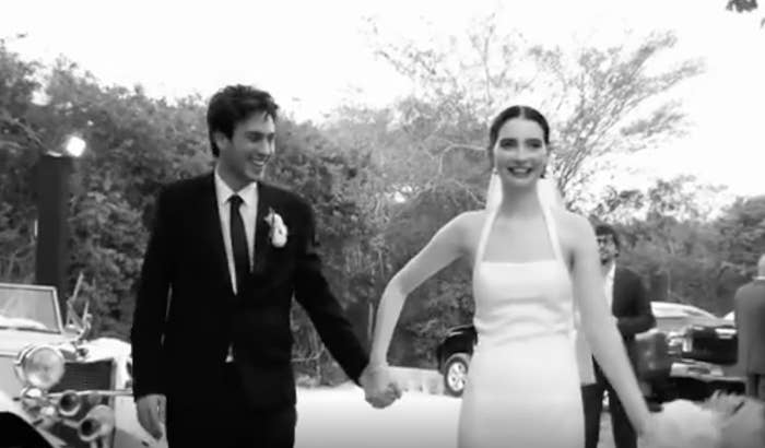 Black-and-white image of the newlyweds hand in hand