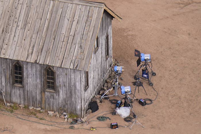 A number of cameras set up around a wooden building surrounded by dirt
