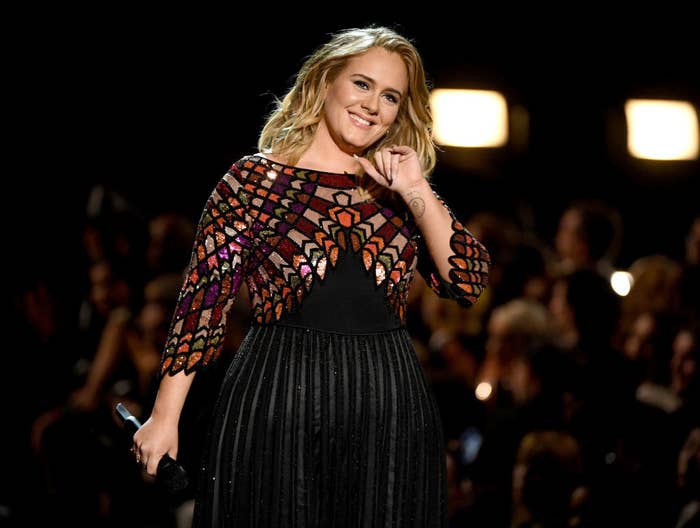 Adele performs onstage during the 59th Grammy Awards in a dress featuring a multicolored top