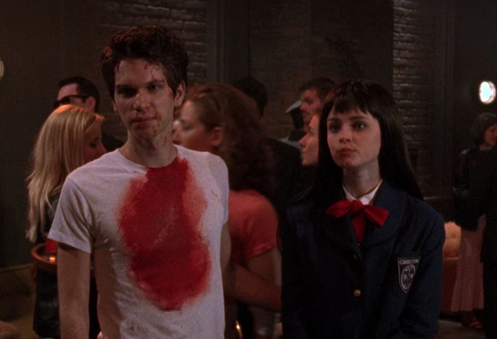 Robert wears a plain t-shirt with a blood stain on it and Rory wears a private school uniform and a long wig