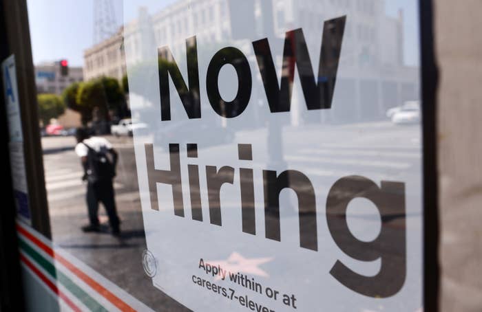 A Now Hiring Sign in a window