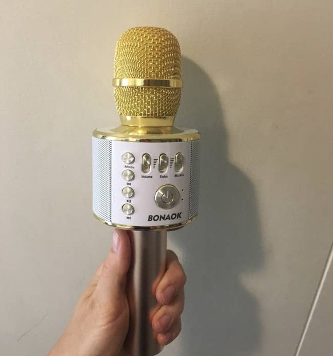 a reviewer holding the yellow karaoke mic 
