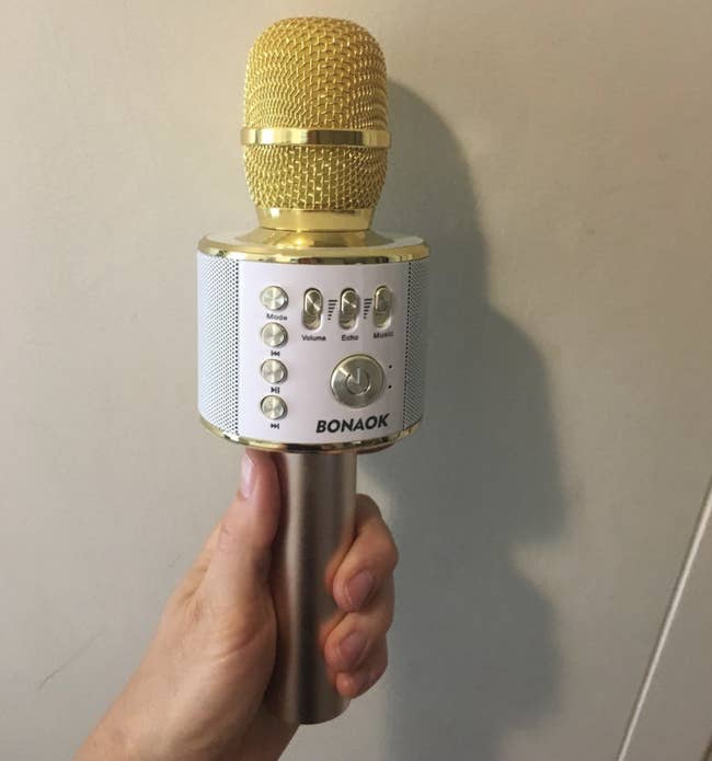 a reviewer holding the yellow karaoke mic 