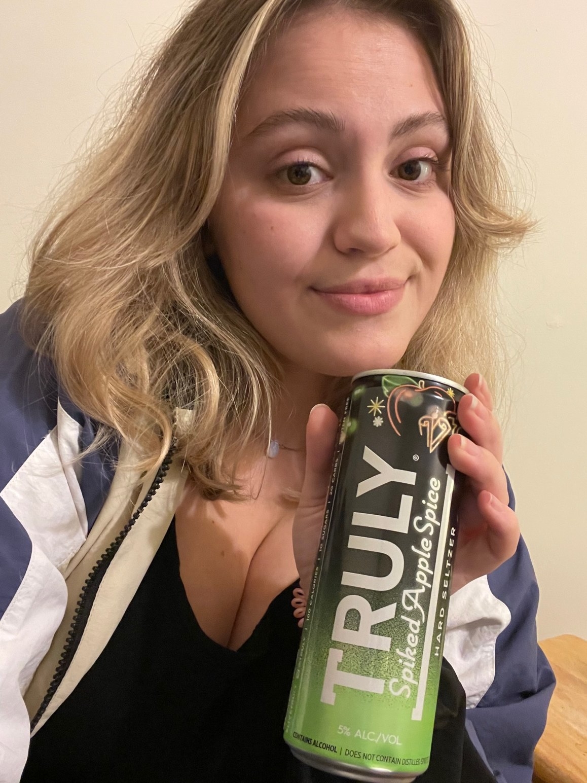 woman holding a spiked apple spice seltzer