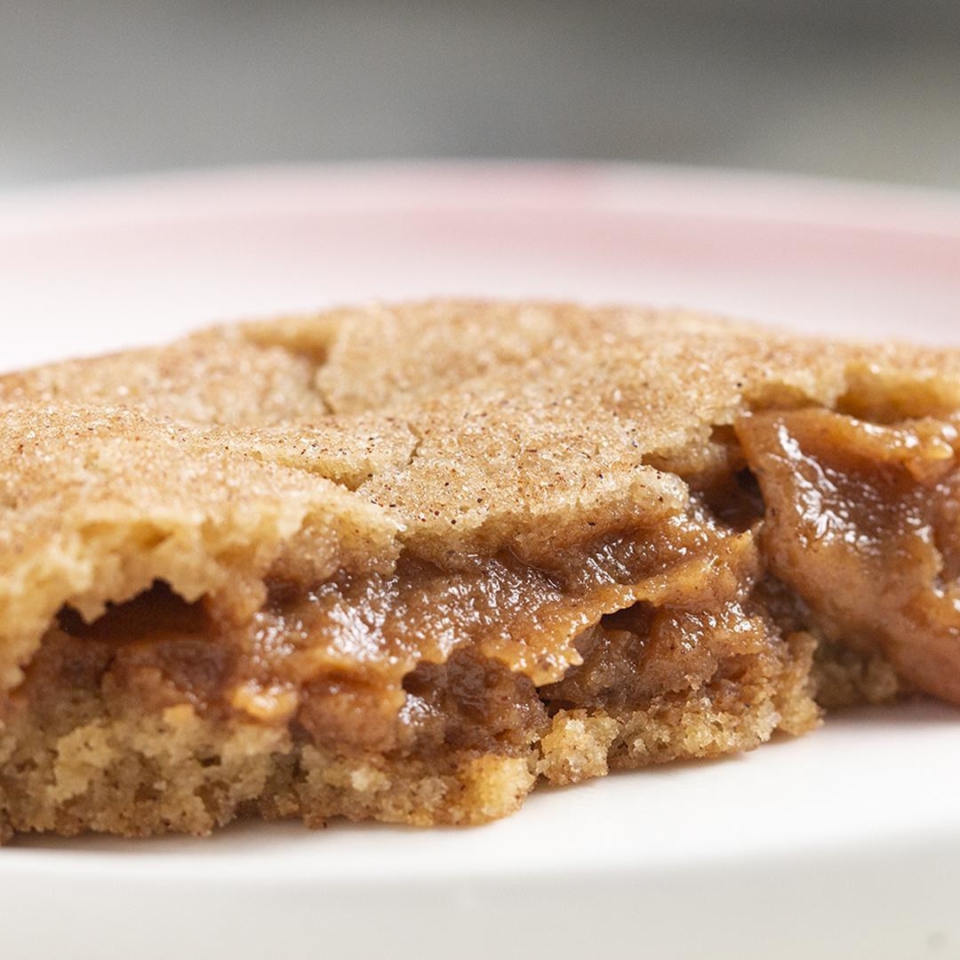 Closeup of a cookie with a gooey caramel center on a plate, highlighting its rich, indulgent texture