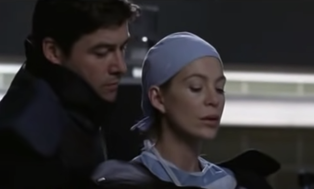 Dylan behind Meredith as she holds the bomb in the patient&#x27;s chest
