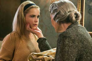 Actress Kiernan Shipka in the movie Flowers In The Attic stares in shock as an older woman grips her face 