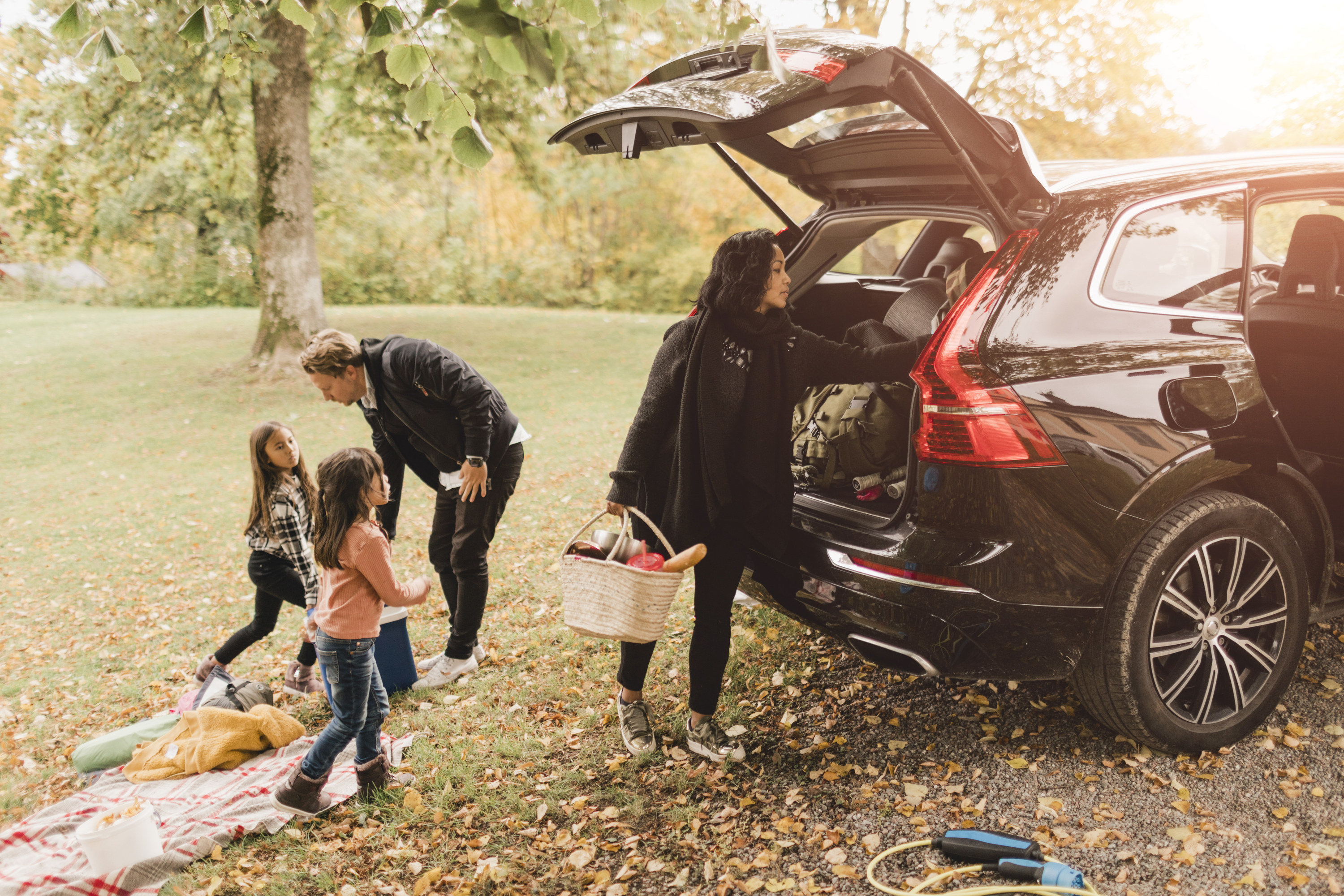 Family unpacking the car for a fall picnic