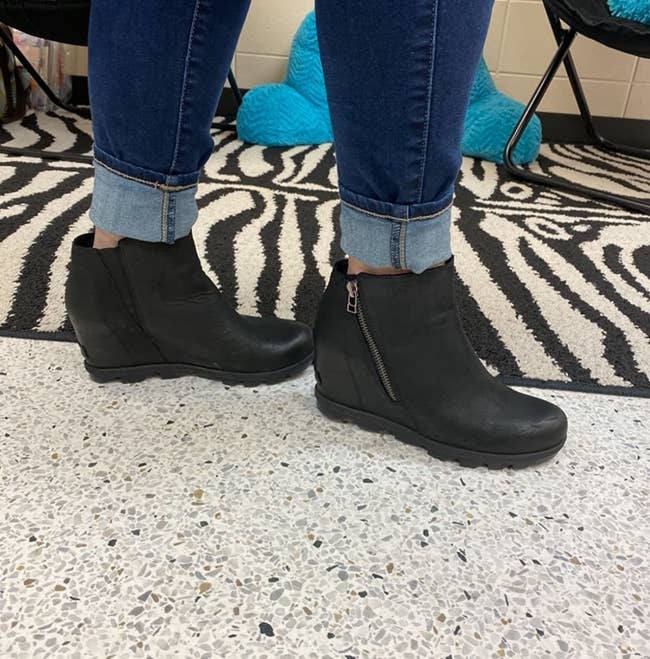 Reviewer is wearing the black wedge boots with a zipper on the side