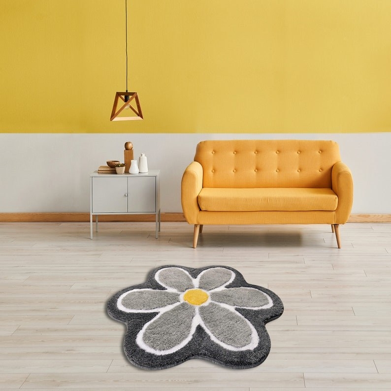 a grey flower-shaped rug with a yellow center. the rug is in a living room