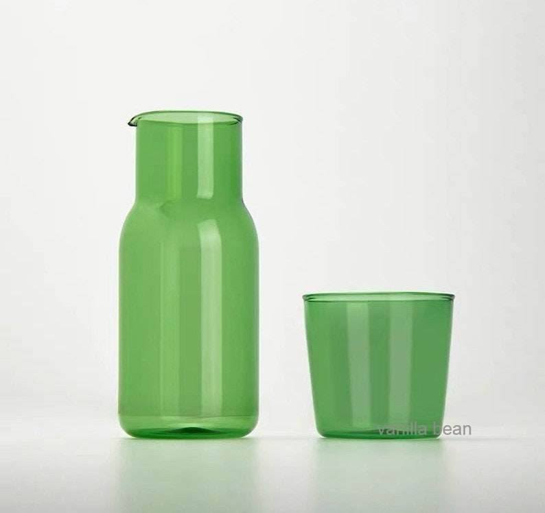 a green glass carafe with a matching drinking glass