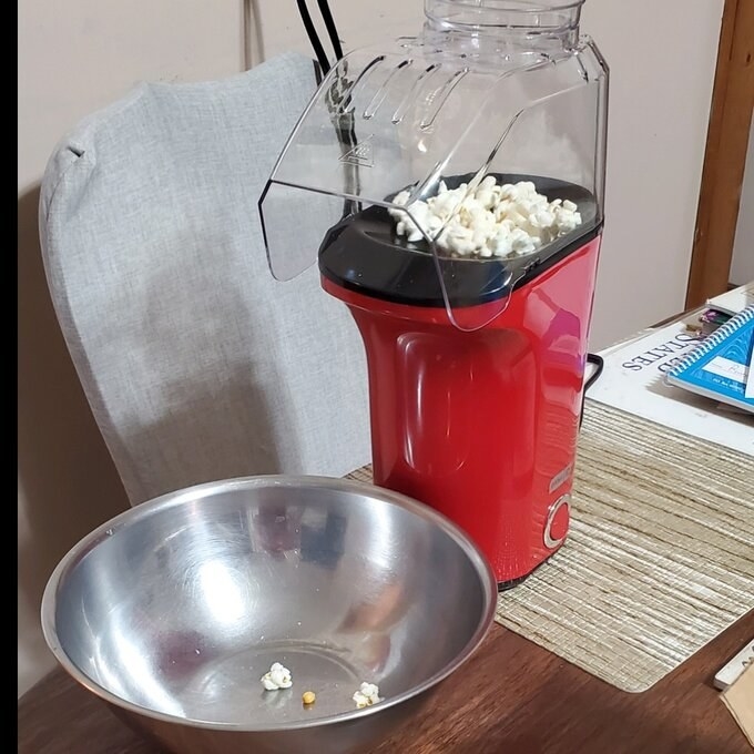 The hot air popcorn popper in white using hot air to pop the kernels
