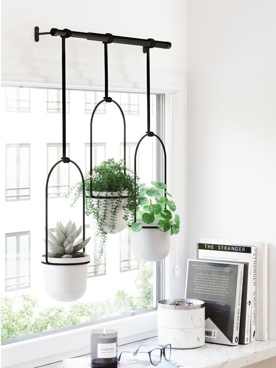 Product image of three white hanging pots in front of a window