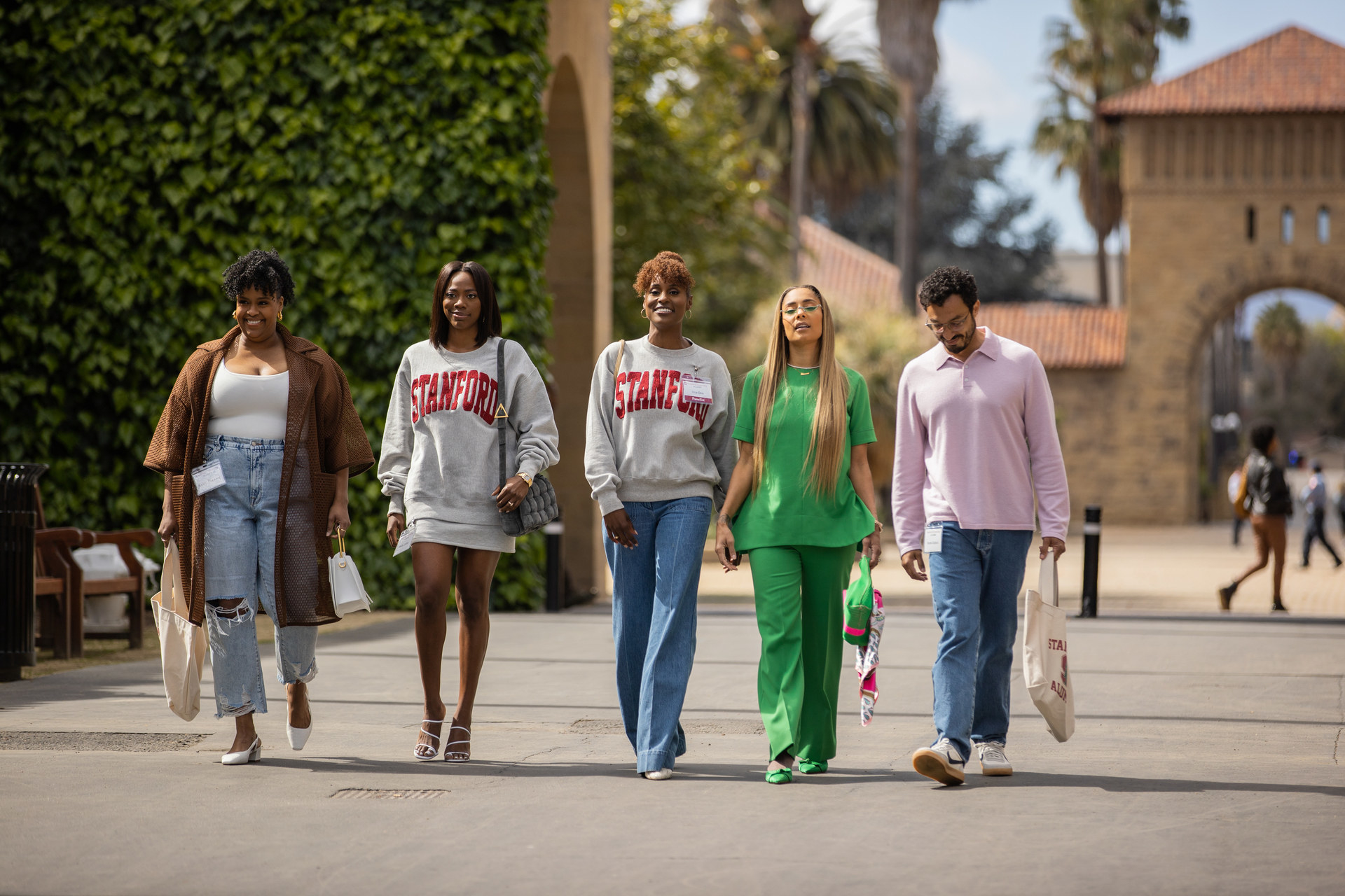 Kelly, Molly, Issa, Tiffany, and Derek walking together on a school campus