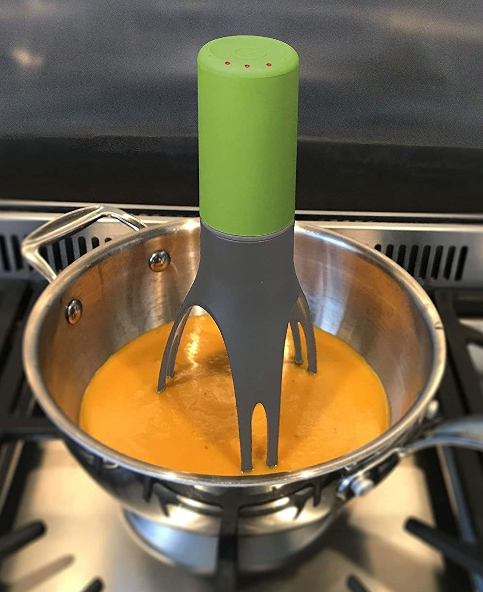 green stirrer mixing up a stew on the stove