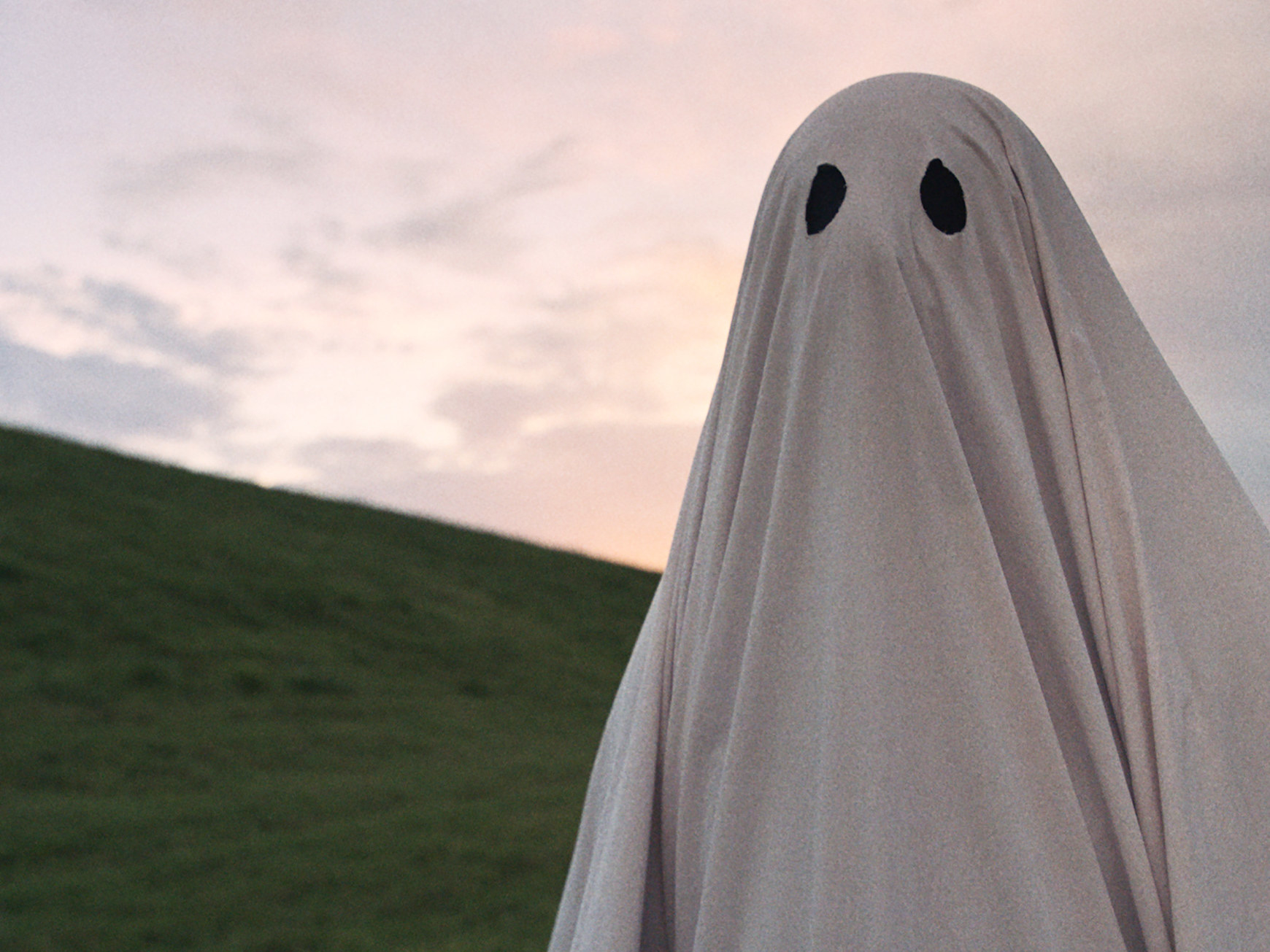 A sheet ghost walks across a hill