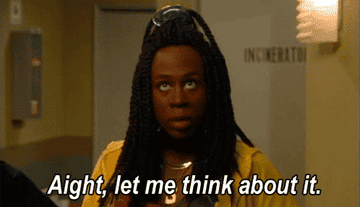 A woman wearing a yellow shirt saying &quot;Aight, let me think about it.&quot;