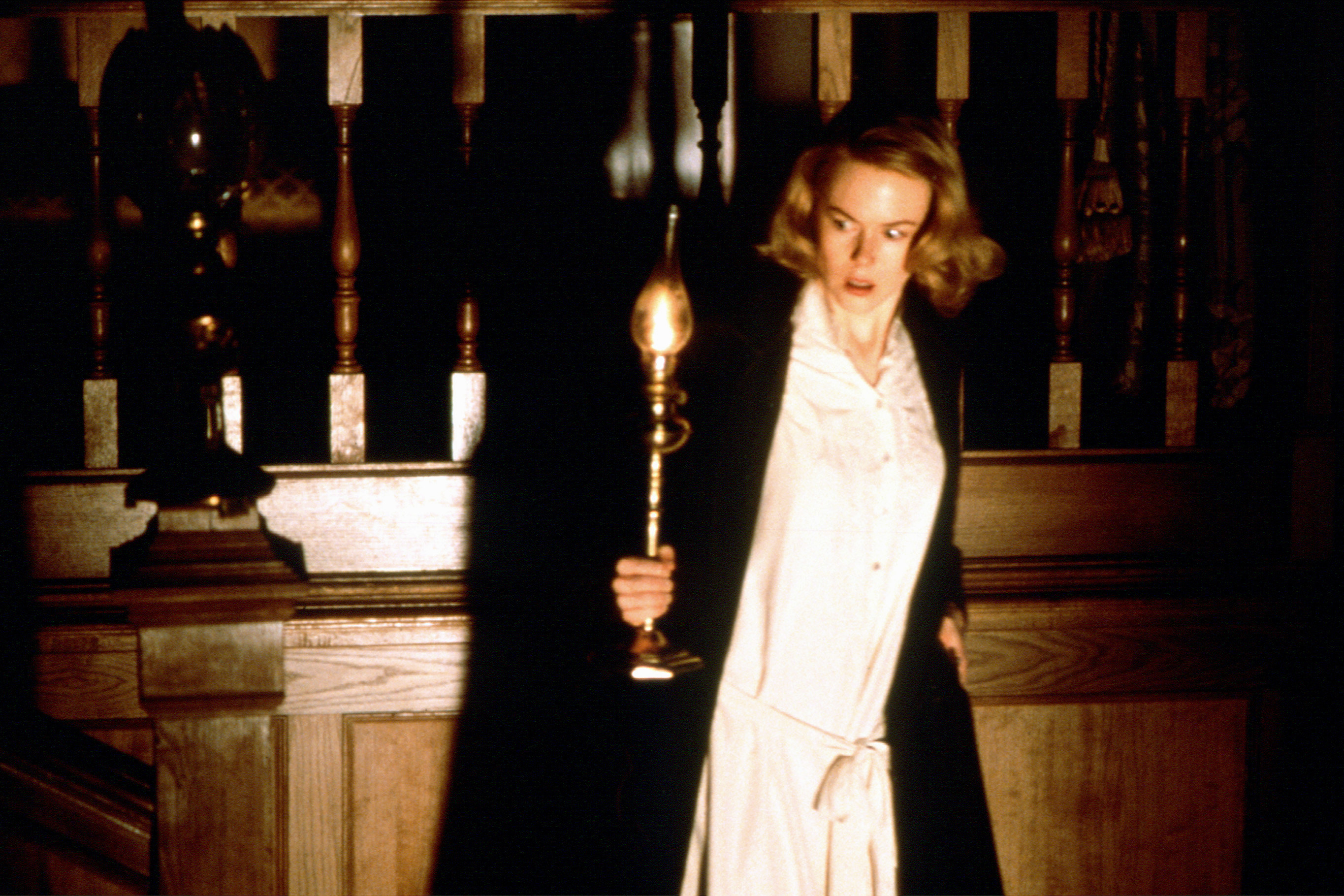 Nicole Kidman holds a lantern in a bathrobe
