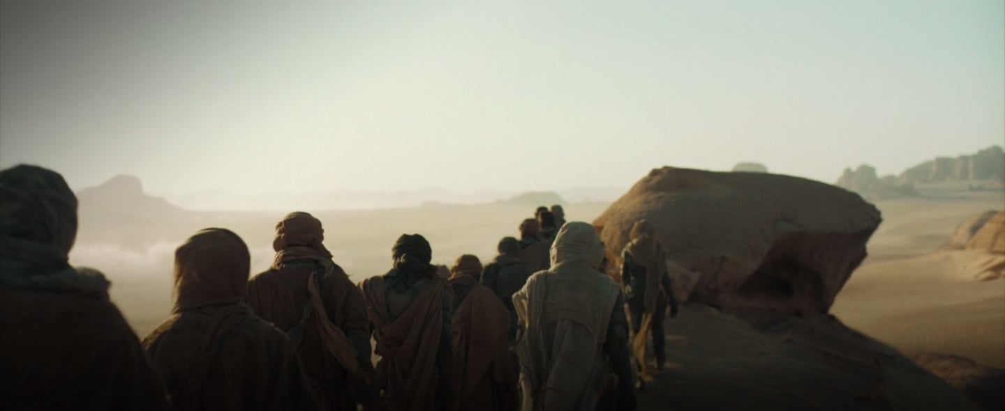 Paul and Jessica walking with the Fremen in "Dune"