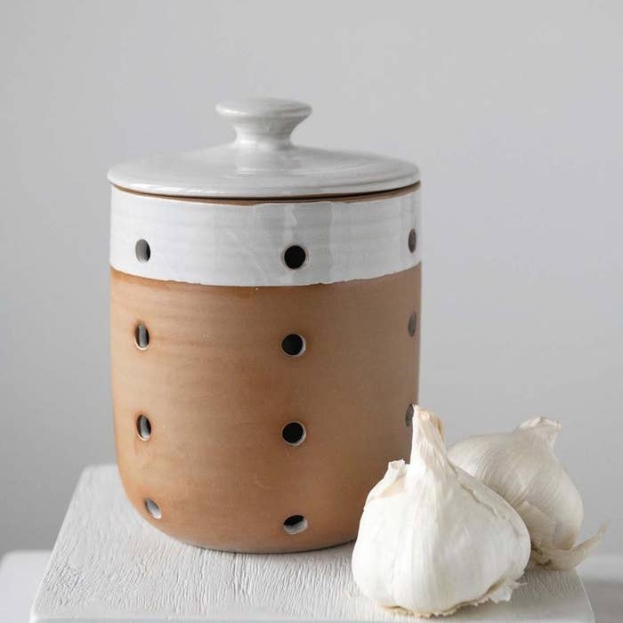 a ceramic jar with holes all over it and a lid on it