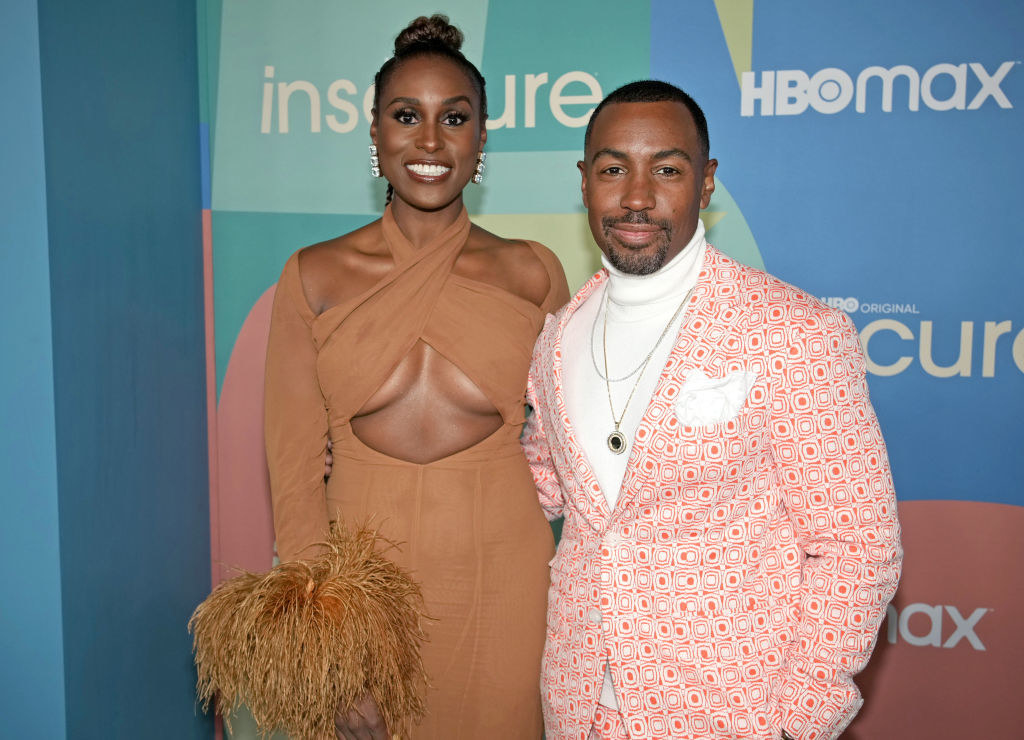 Issa and Prentice at the Season 5 premiere, she wears a tan cut-out long-sleeve dress and he wears a white turtleneck with a patterned salmon suit