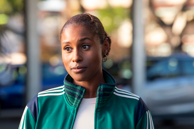 Still of Issa from &quot;Insecure,&quot; she looks off camera and wears a &#x27;90s-style vintage green tracksuit