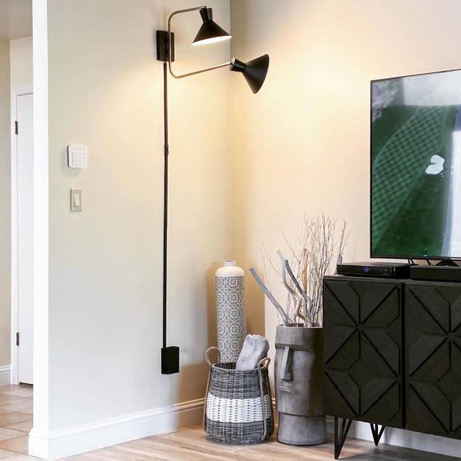 Reviewer's black wall mounted sconce is shown in a living room corner