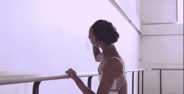 Dancer hitting her pointe shoes against the wall.