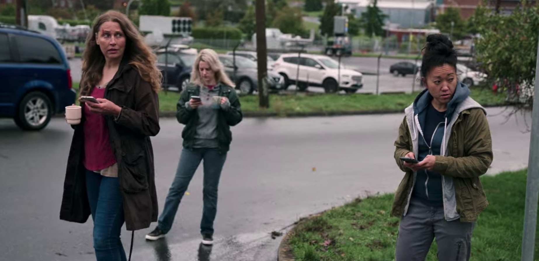 Women from the domestic violence shelter stare at Alex while they try to use their phones